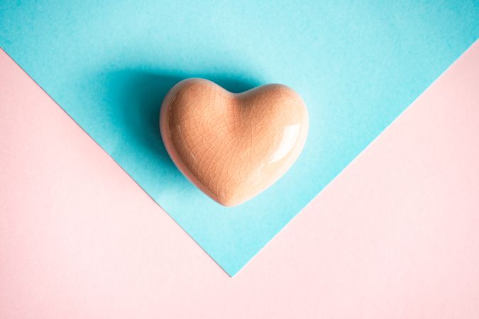 Orange heart ornament on pastel table 