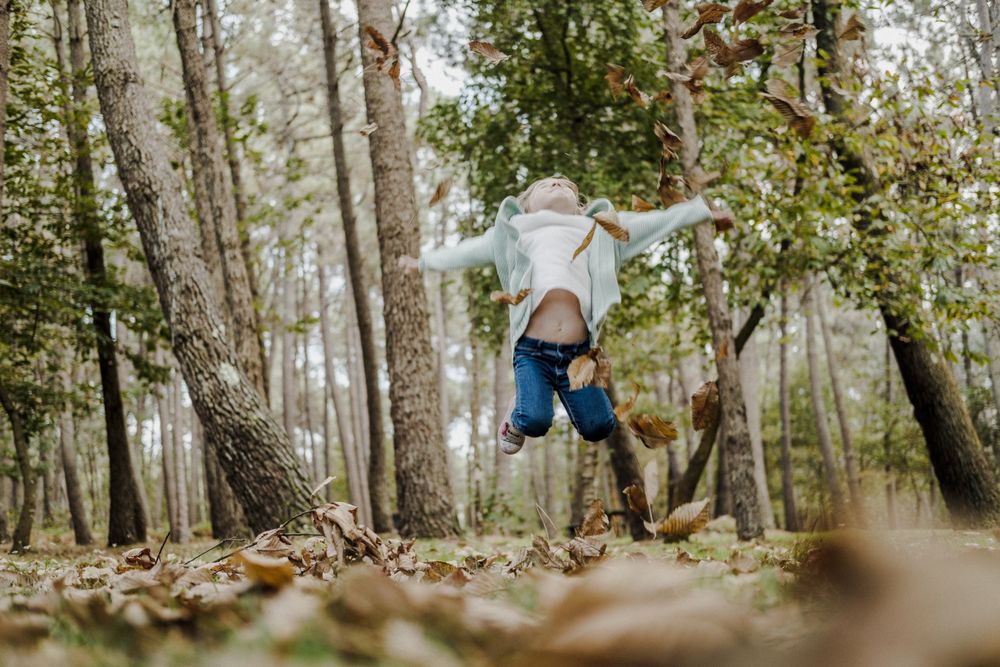 Smiling girl between meadow with dry leaves