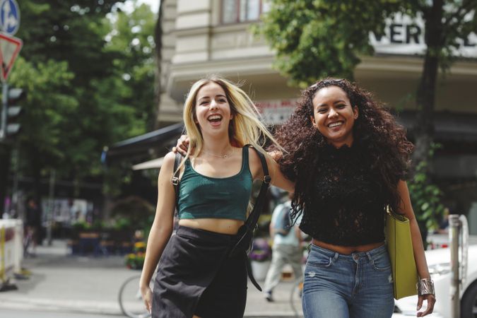 Cheerful friends walking on city street