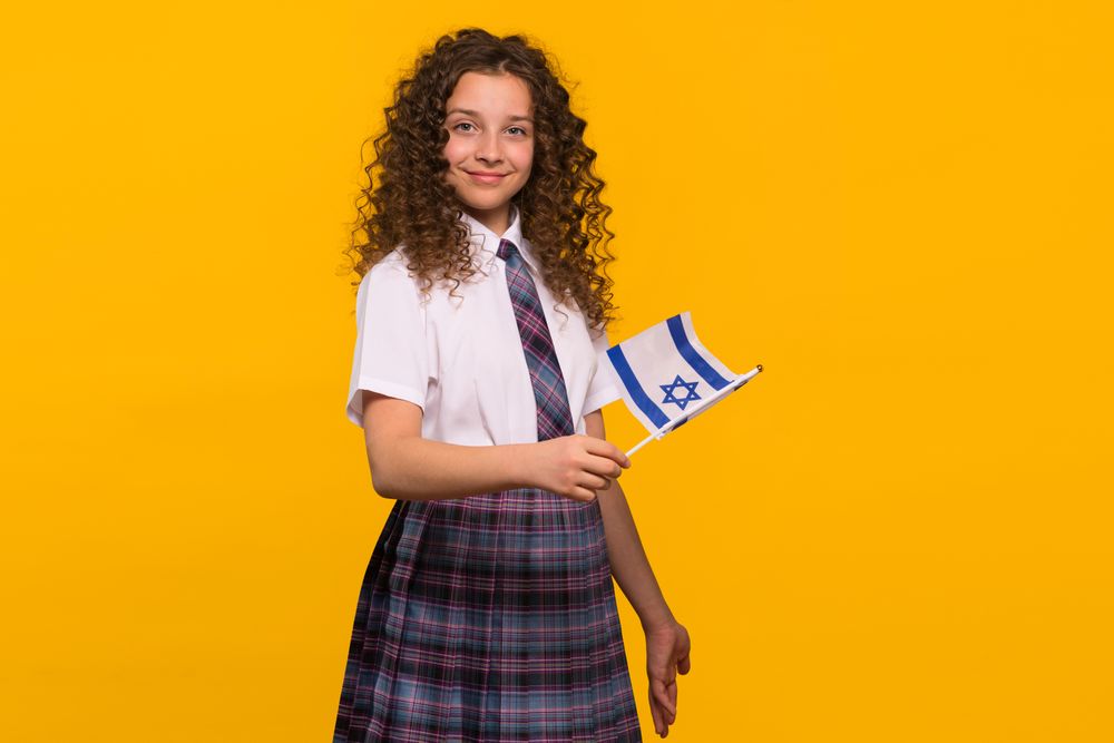 Girl in school uniform holding Israeli flag