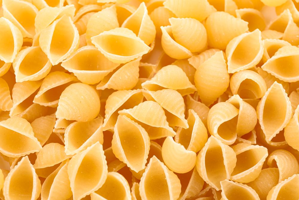 Pasta as background, closeup. Uncooked whole wheat pasta
