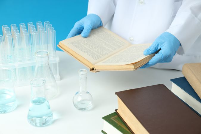Flasks, books and doctor on blue background