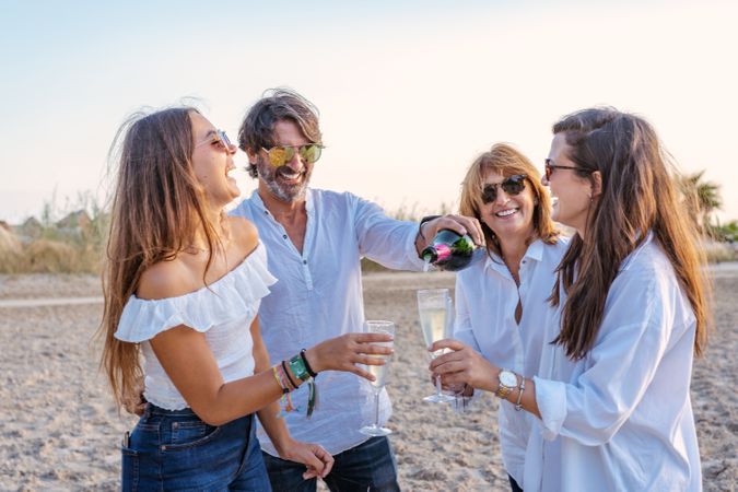 Happy family drinking wine on beach