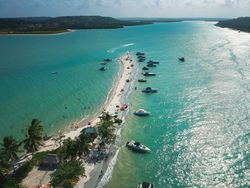 Sand going out into the water with anchored boats in Brazil
