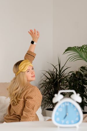 Woman stretching with smartwatch, plants in background