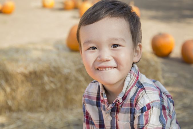 Smiling Biracial Young Boy Having Fun at the Pumpkin Patch