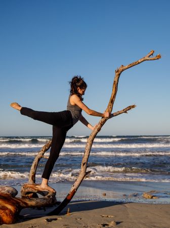Young woman dancing and posing near water on shore