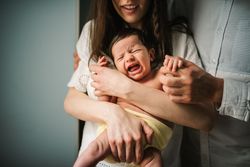 Crop parents comforting crying baby