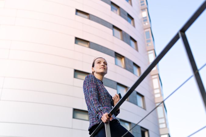 Serious businesswoman leaning on railing