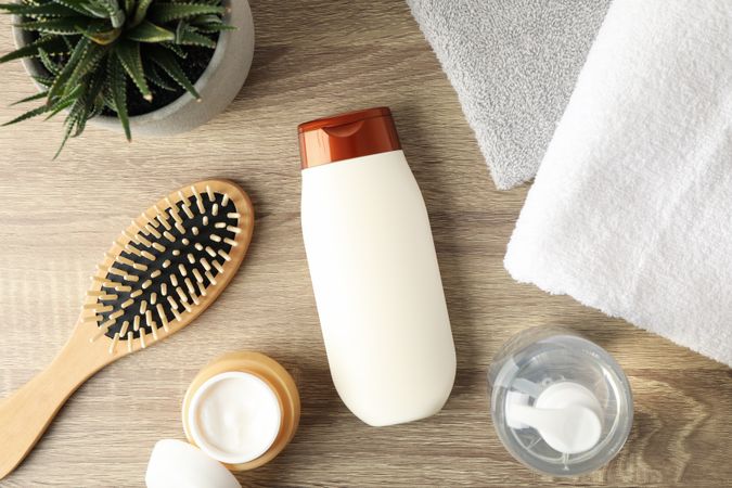 Composition with hair care products on wooden background, top view