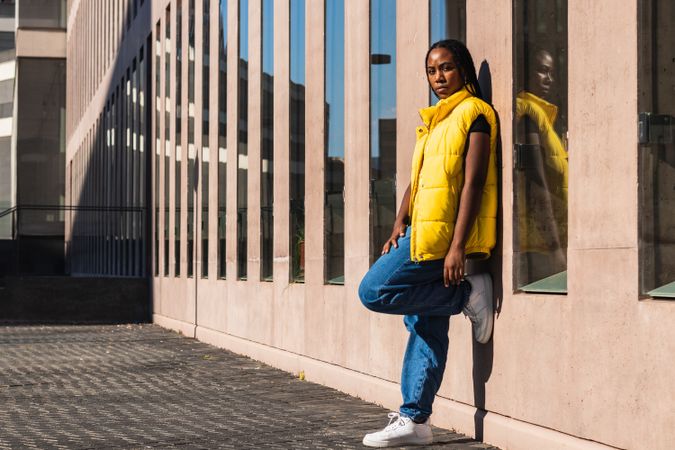 Trendy woman leaning on building wall