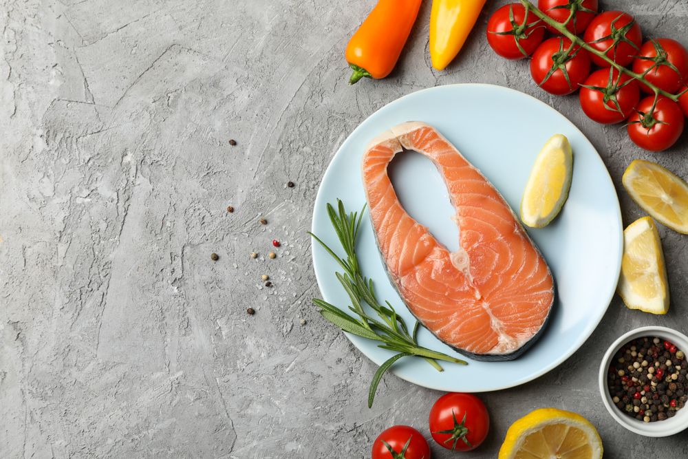 Composition with salmon meat and ingredients on gray background, top view