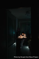 Young man studying in a dark room 0LWeDb
