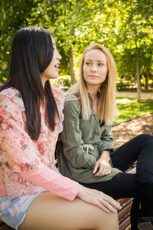 Multiethnic friends speaking on bench
