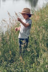 Boy in straw hat on riverside