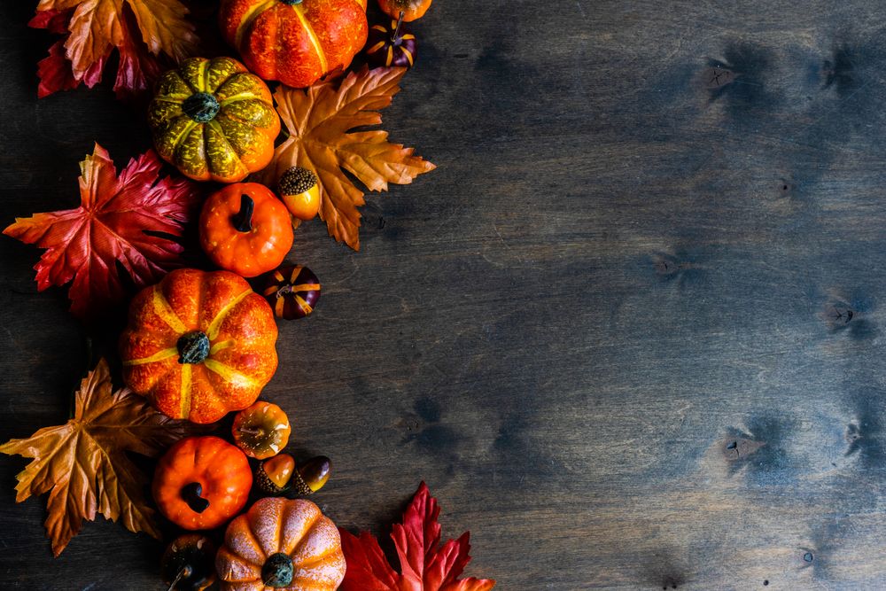 Top view of wooden table with pumpkin decorations and leaves with space for text