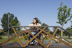 Smiling woman in a wheelchair on a bridge, vertical
