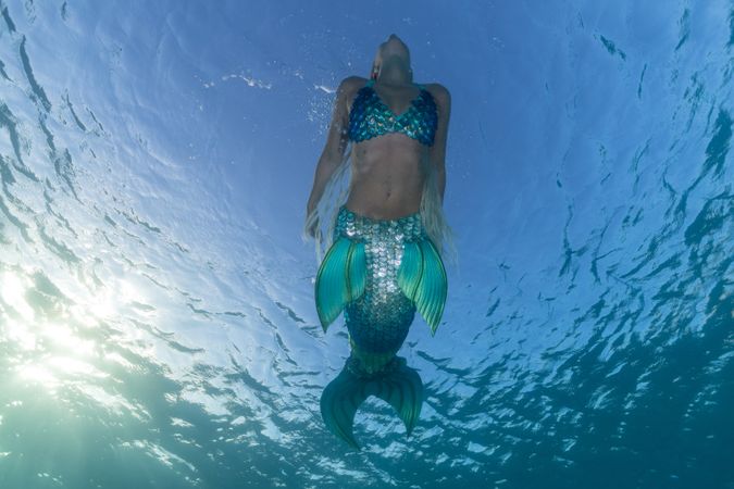 Redhead fairytale female mermaid swimming underwater