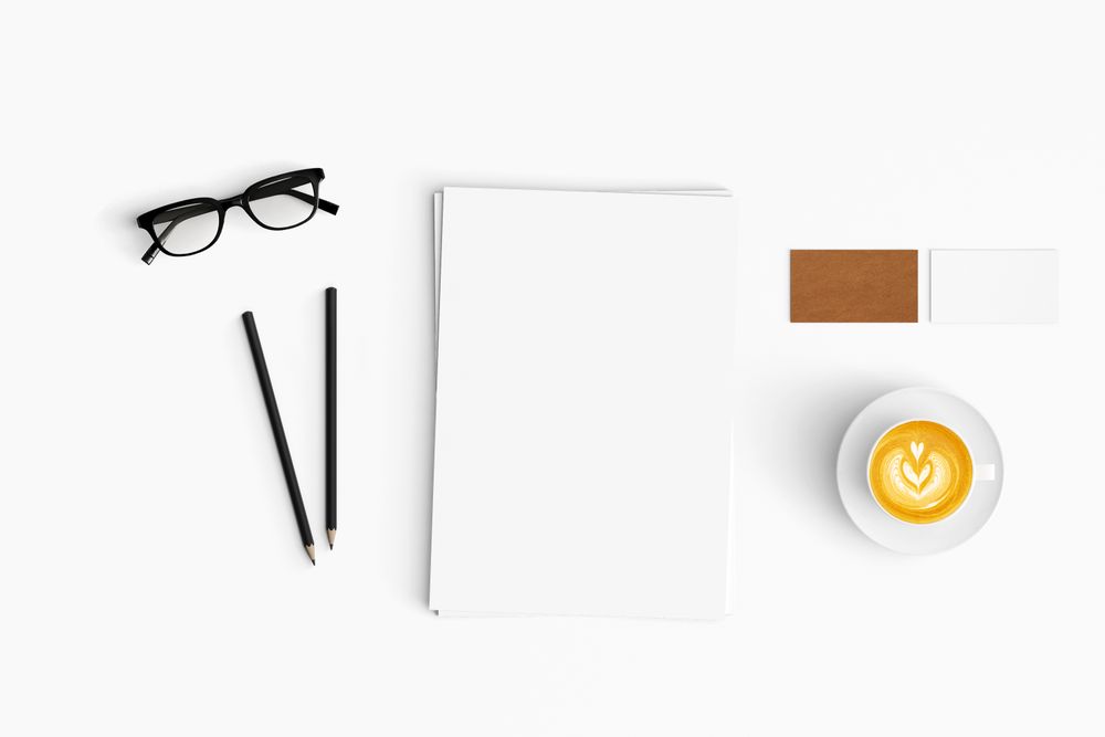 Modern workspace with coffee cup, paper and pencils copy space
