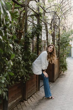 Woman sitting on planter in garden