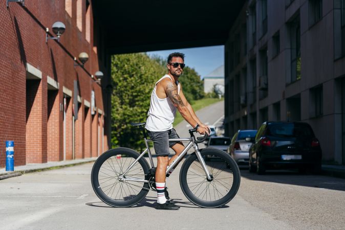 Man riding bike next to buildings