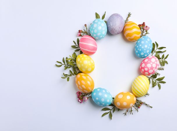 Decorative Easter eggs and flowers on neutral background, space for text. Top view