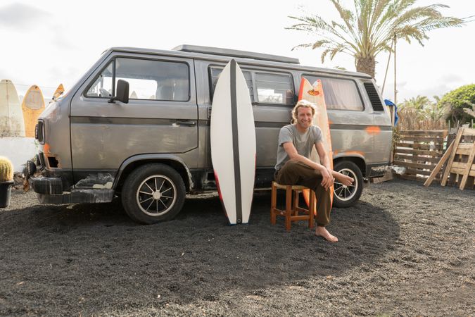Man standing near surf boards and van