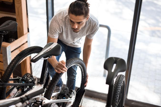 Man inspecting a bicycle wheel for alignment