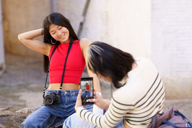 Woman posing as her friend takes her picture
