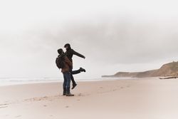 Couple kissing on sand shore near water