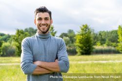 Confident smiling man standing in a park 0LdLYA