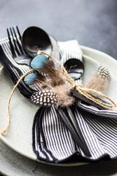 Table setting with feathers on concrete background