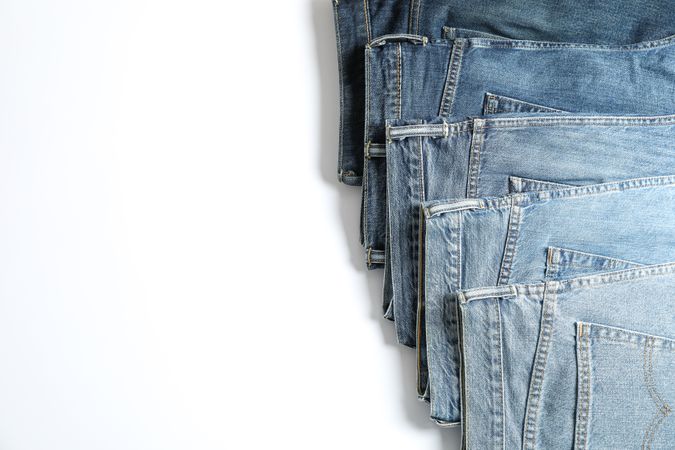Jeans of different colors isolated on light background, space for text