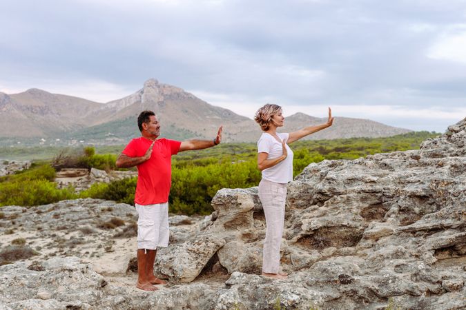 Couple meditating on rock