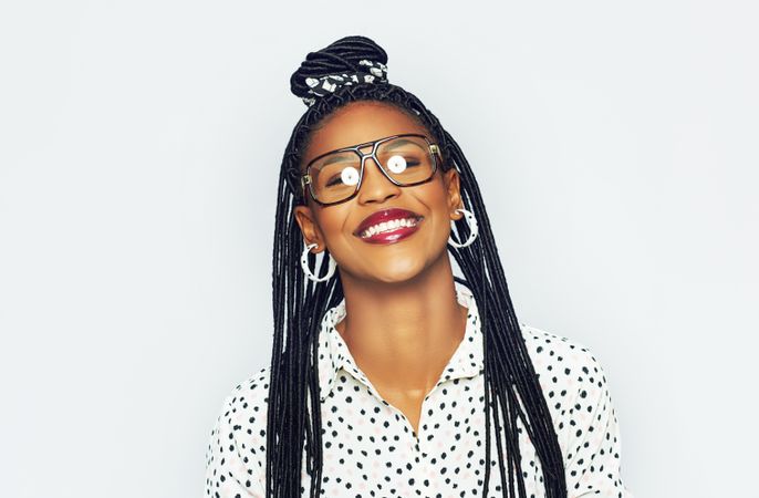 Studio portrait of smiling woman wearing glasses on a bright background