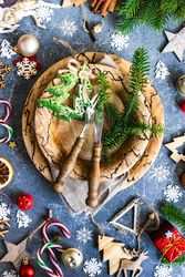 Rustic table setting surrounded by Christmas decorations and fir scattered on marble table