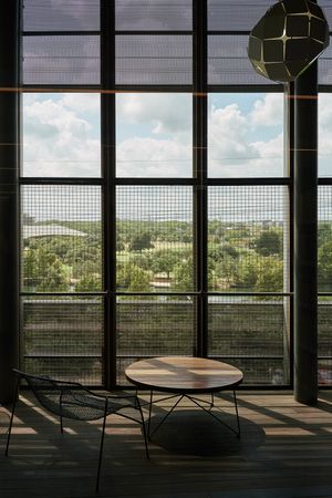 Round table nearby big windows with grid in sunlight