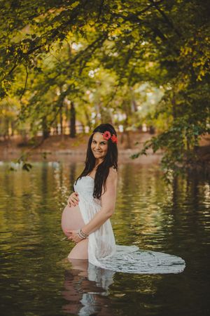 Pregnant woman standing in lake water