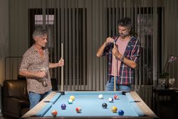 Men standing near pool table