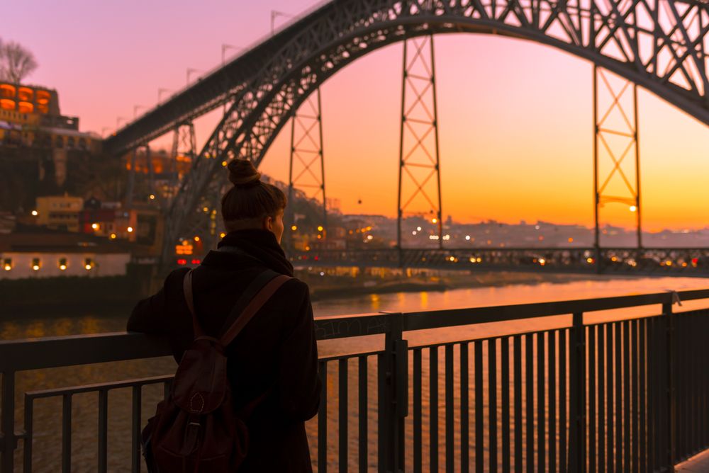 Woman looking at river and city in evening