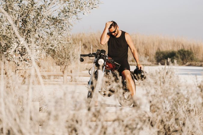 Serious male driving motorcycle in forest
