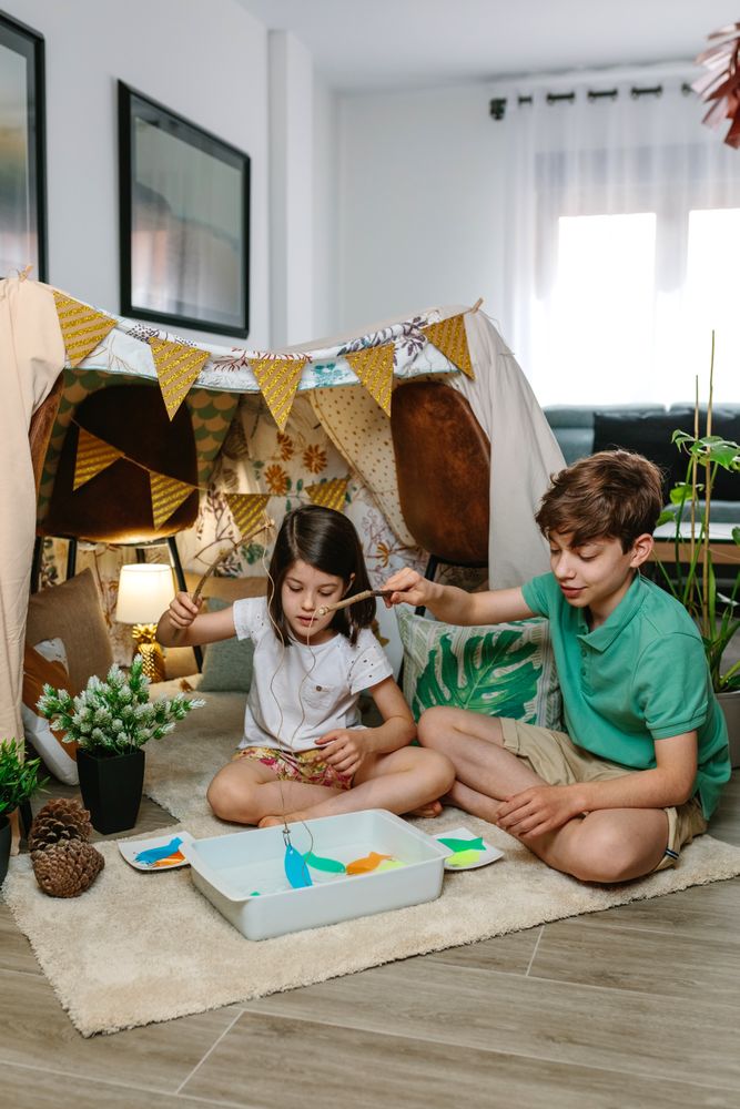 Children camping at home playing fishing game