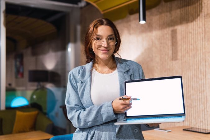 Glad businesswoman showing data on laptop
