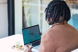 Anonymous Black man with espresso and glass of water in cafe