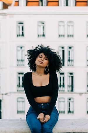Fashionable Black female relaxing in city