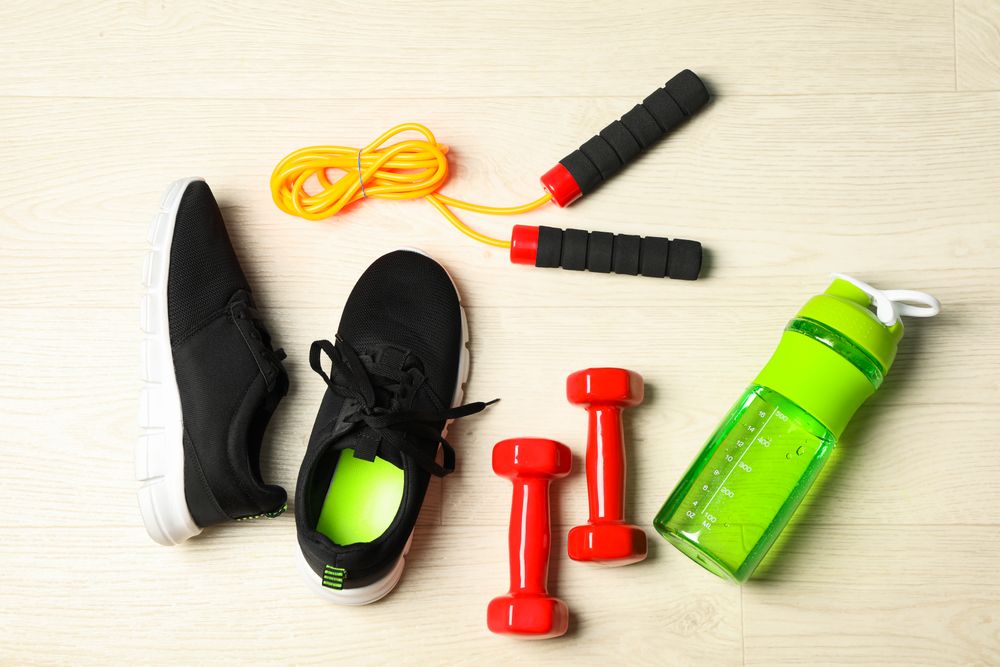 Healthy lifestyle accessories on blank background, top view