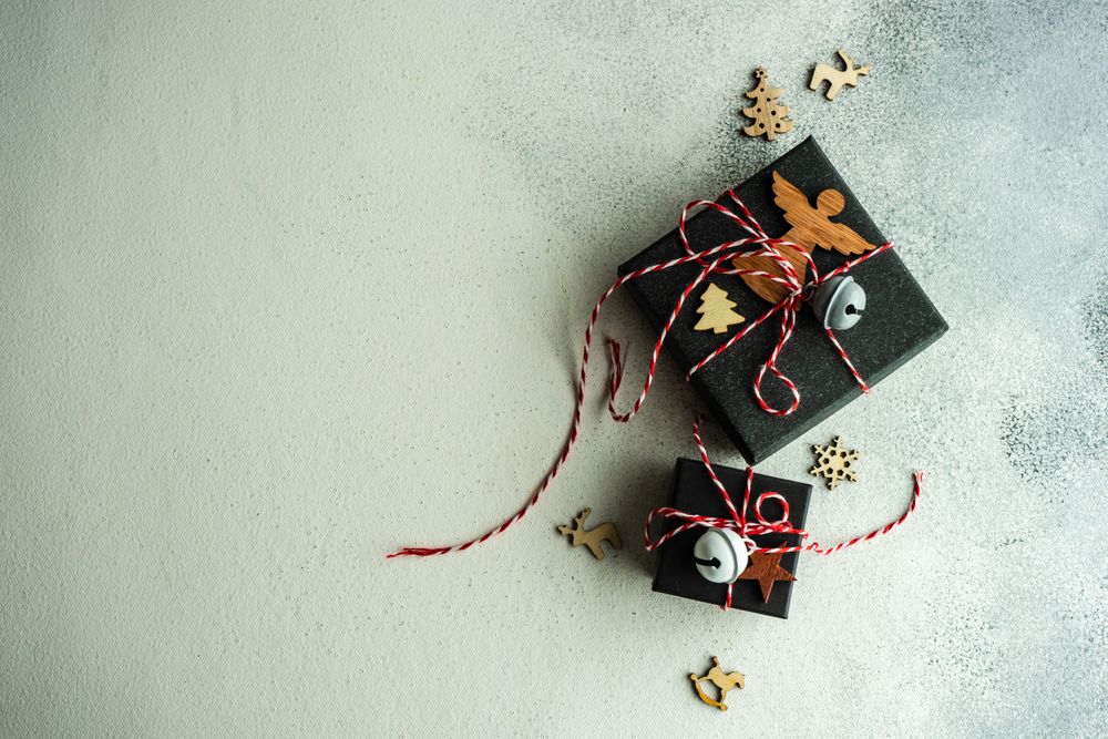 Top view of Christmas gift boxes with holiday decor on stone background with copy space