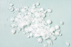 Scattered crushed ice on baby blue background