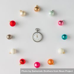 Circular border of colorful Christmas bauble decorations on light background with clock 0Kg2Z0