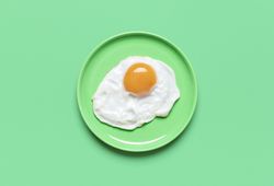 Fried egg on green plate, view from above